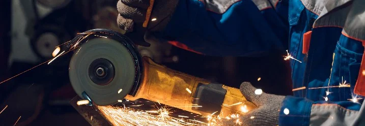 Person schneidet Metall mit einer Flex.